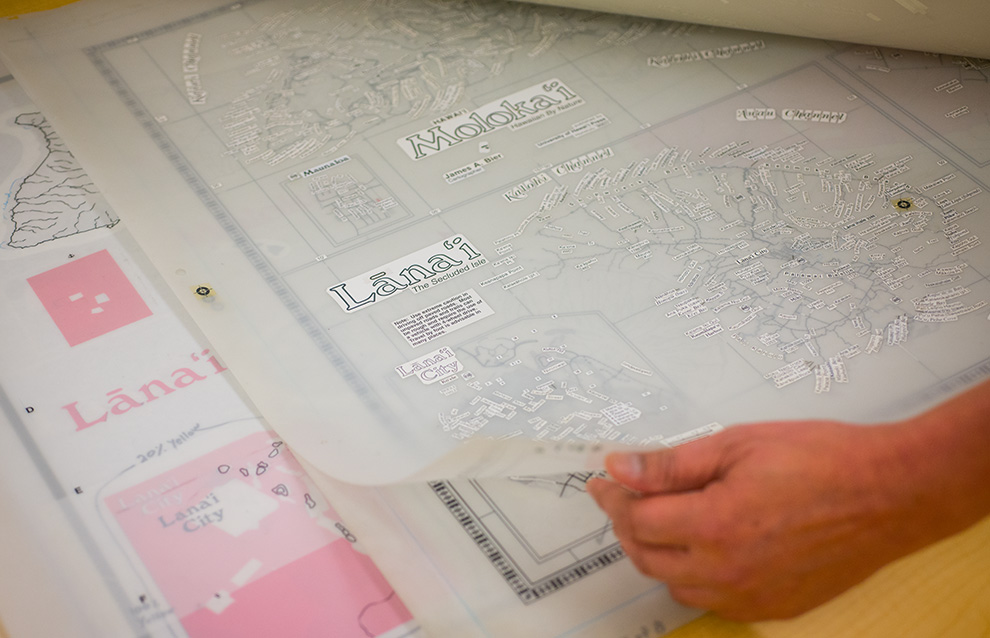 a hand holding a clear plastic sheet with a map