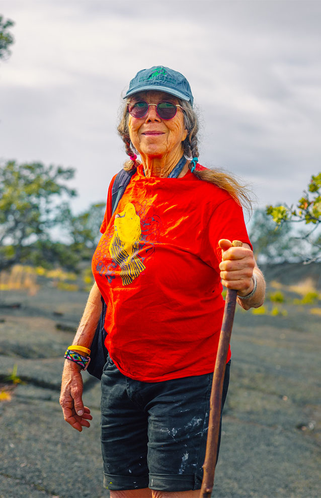 a person in a red shirt wearing hiking gear and a walking stick