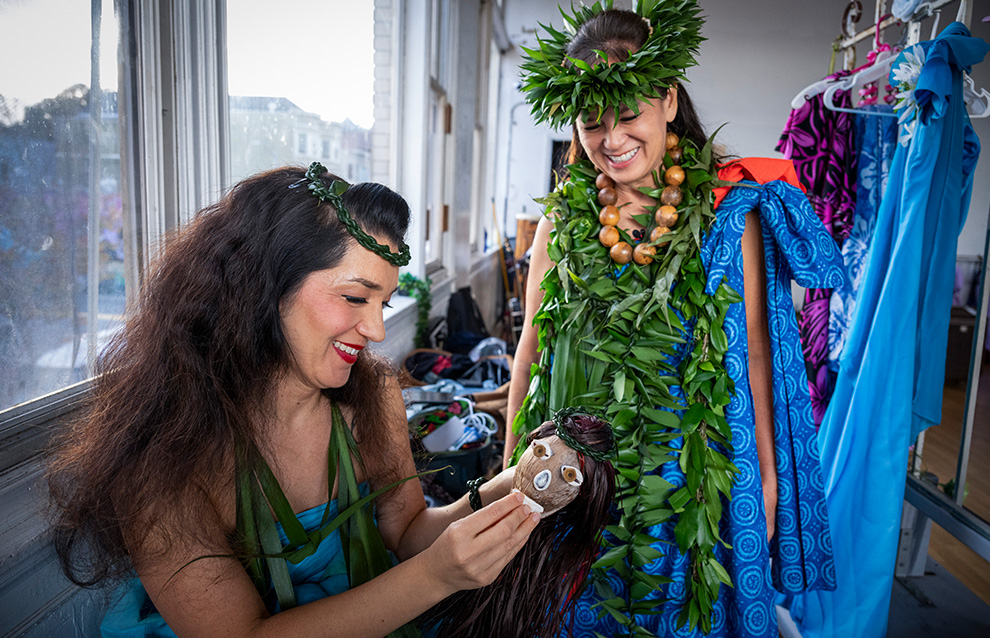 a person helping someone with accessories of their costume'