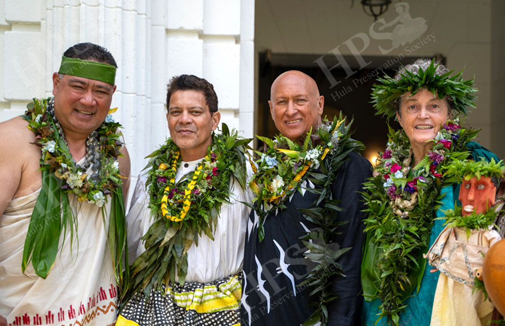 a group of people wearing leis taking a photo