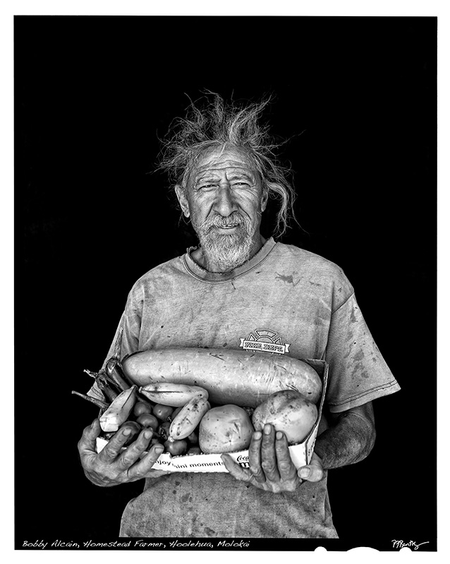 a person holding a box of vegetables