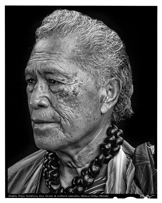 a person with grey hair and a necklace