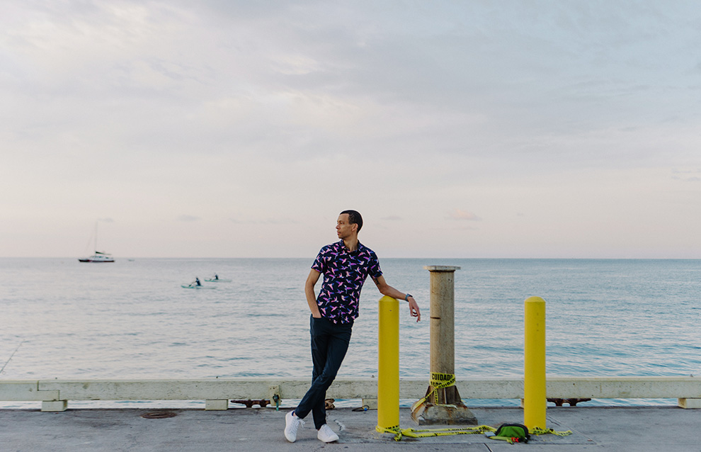 a person leaning on a railing by the water