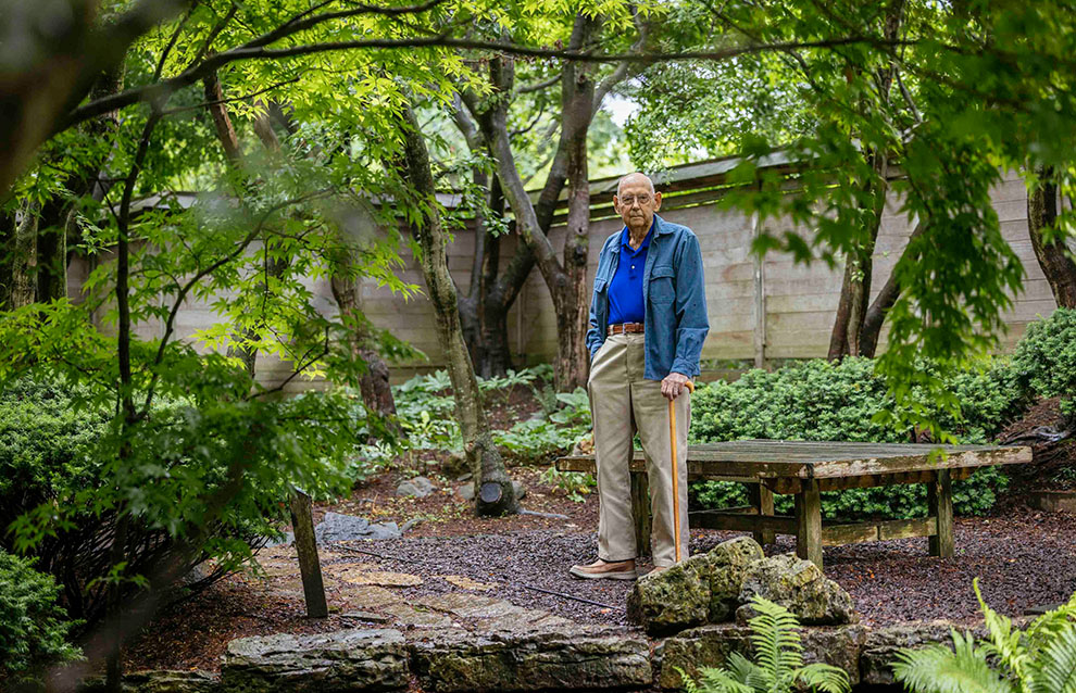 an old person standing in a garden