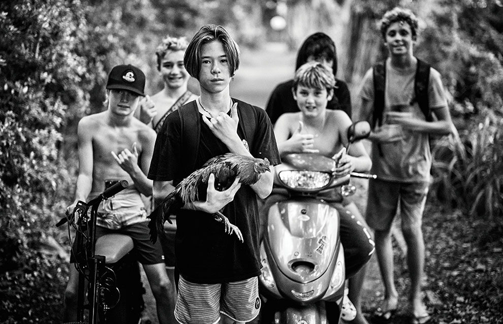 a group of childs standing next to a scooter and a bird