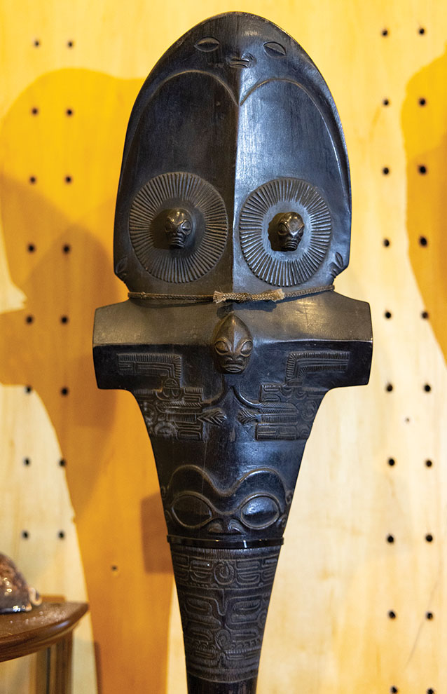 a black statue with a face and a rope