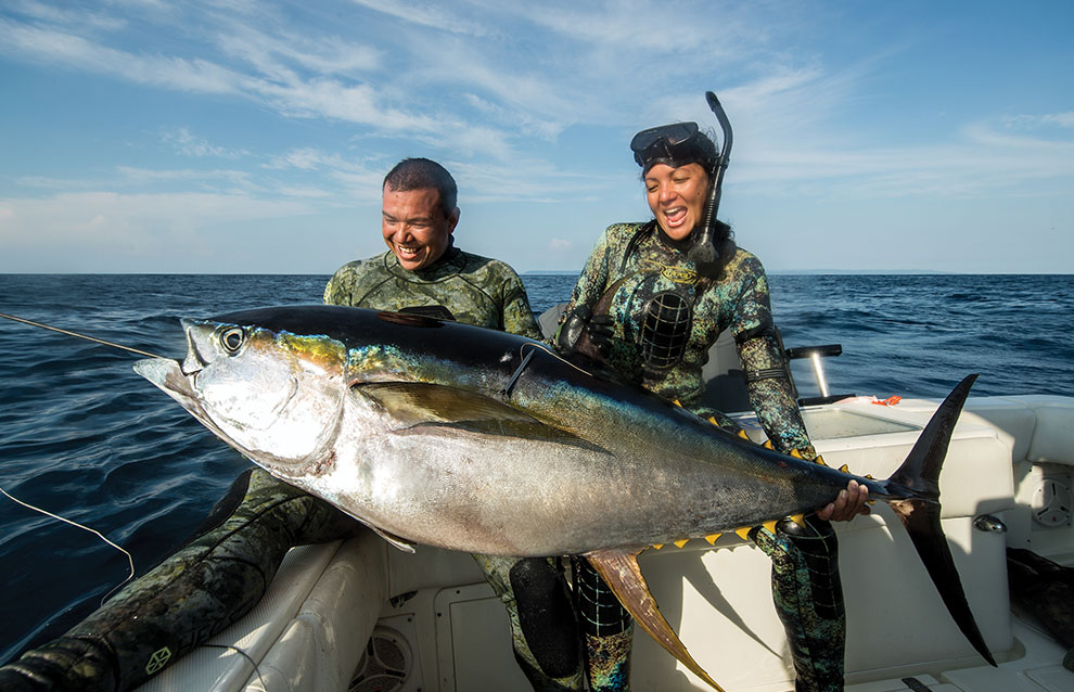 a person and person in scuba gear holding a fish