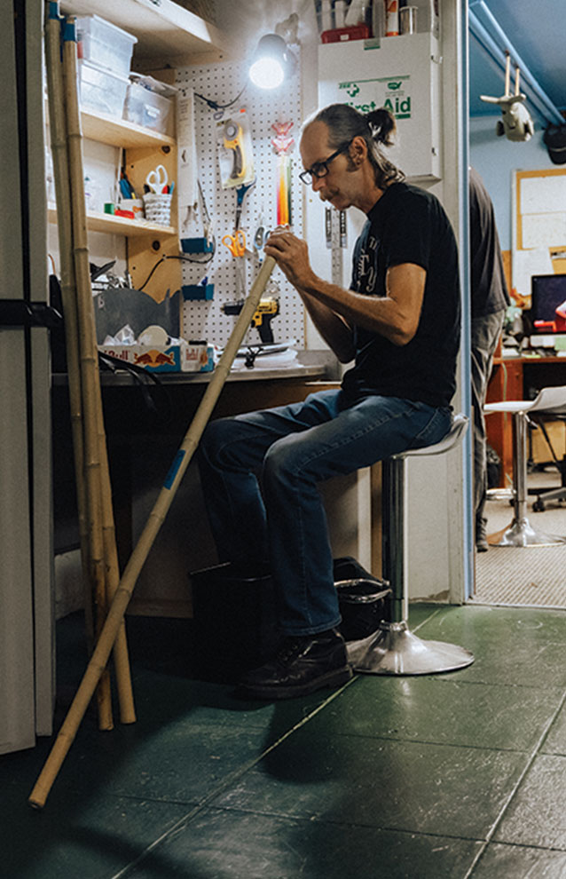 a person sitting on a stool with a broom