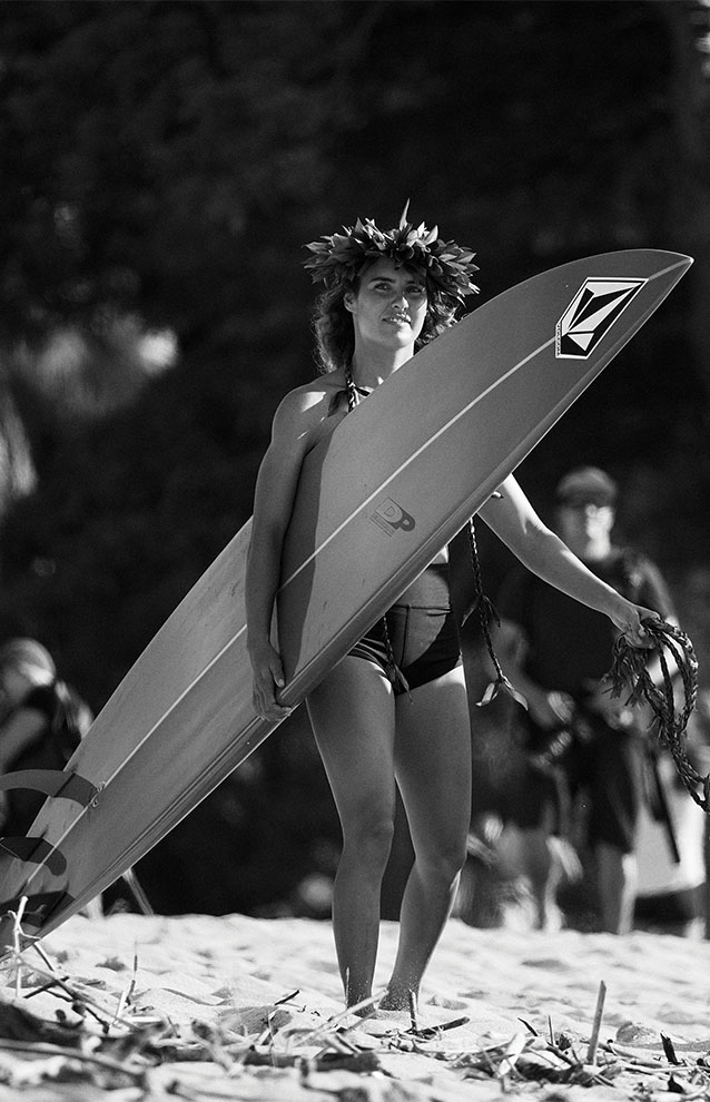 a person in a bathing suit holding a surfboard