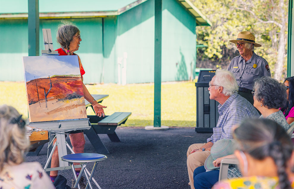 a group of people observing a painting