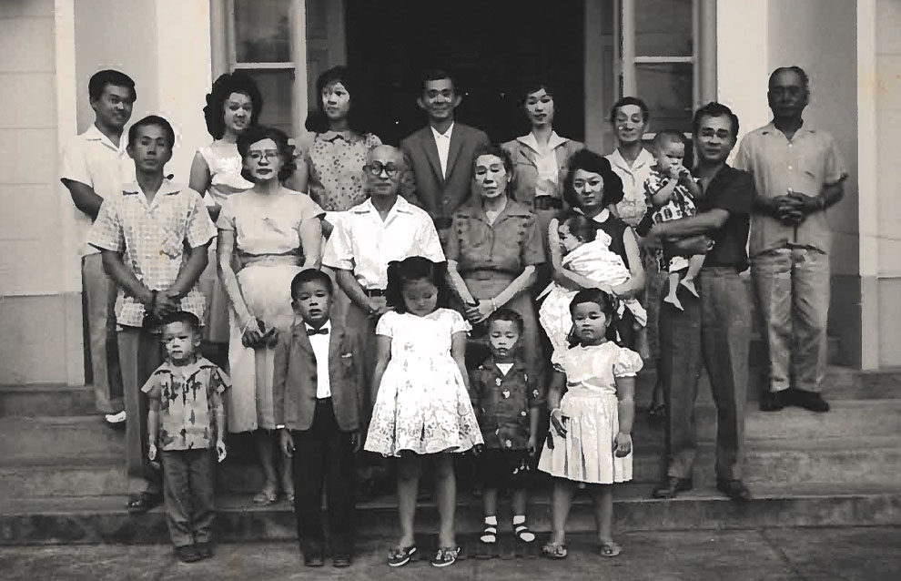 an old photograph of a huge group of people standing in front for a doorway