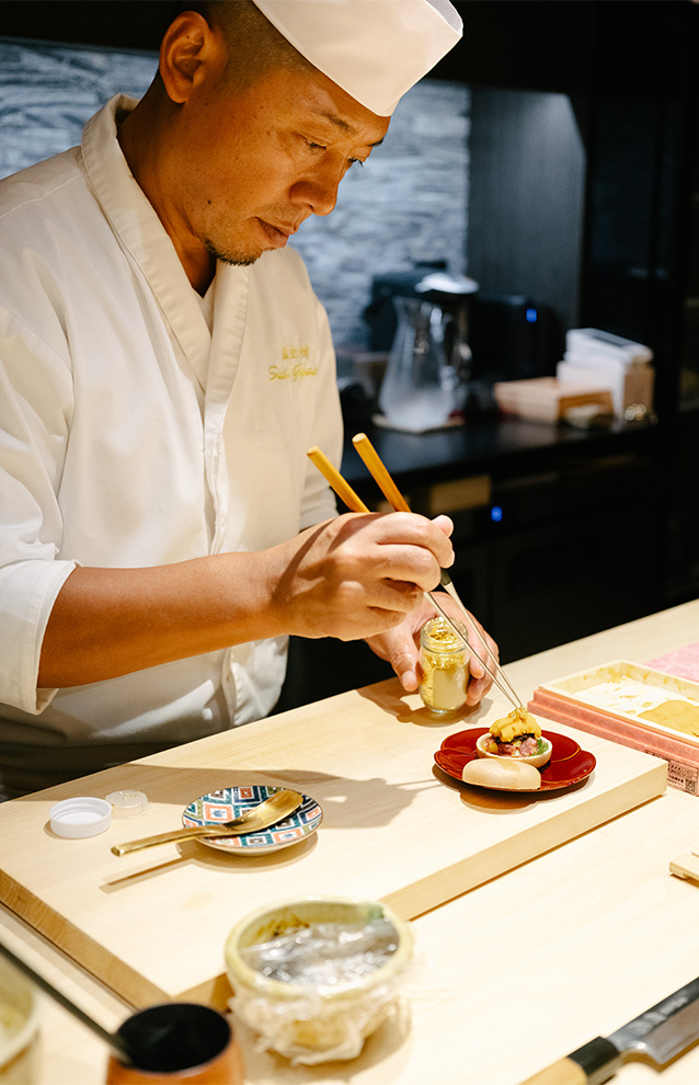 a photo of a chef preparing a dish of sushi