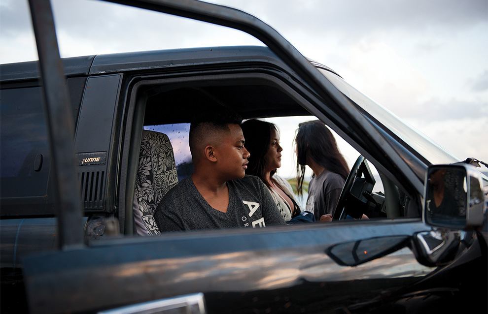 three people sitting inside of a black car