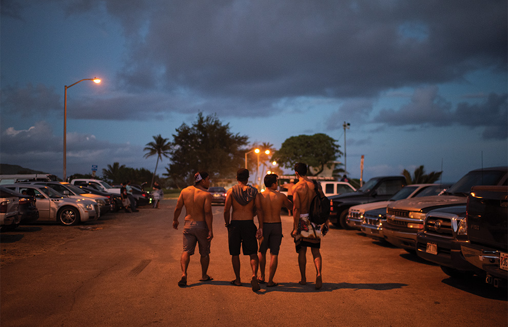 group of people walking in a parking lot row of cars during dawn