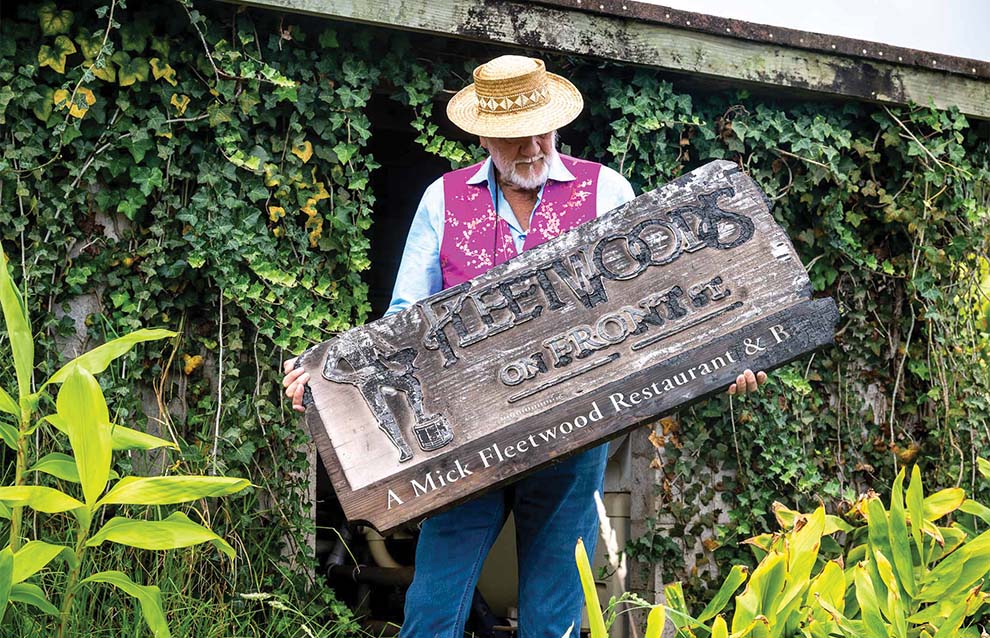a person holding up an old weathered sign