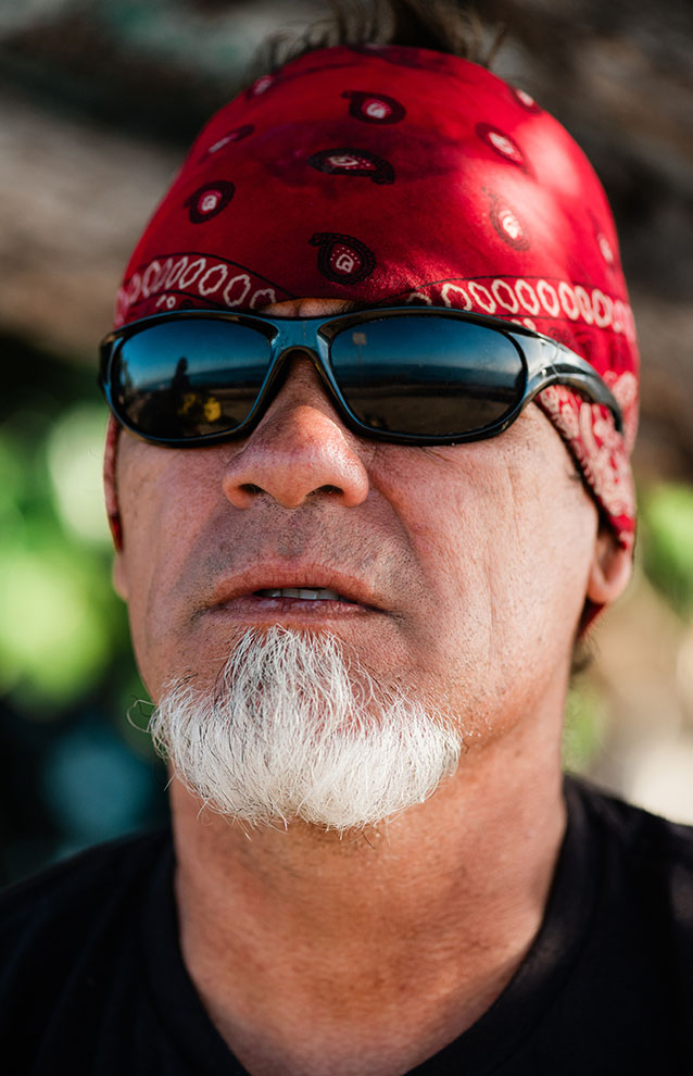 closeup portrait of a person with white beard wearing a bandana and sunglasses