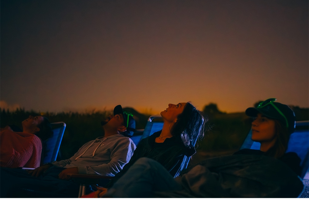 a group of people looking up at the sky with binoculars