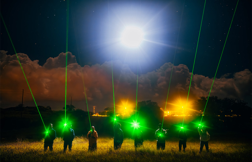 a group of people with lights, observing the night sky