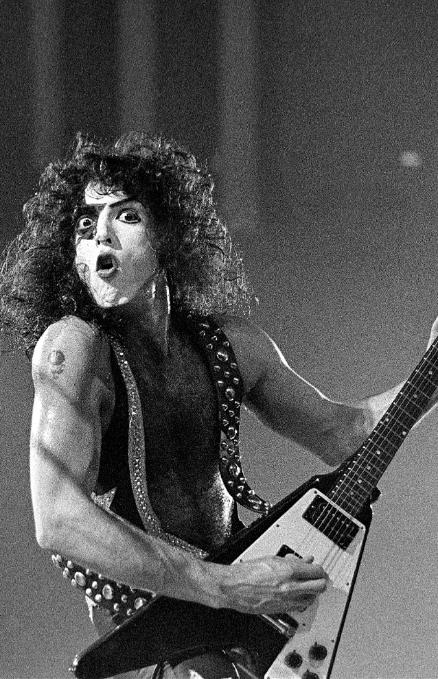 a person performing on stage, playing an electric guitar