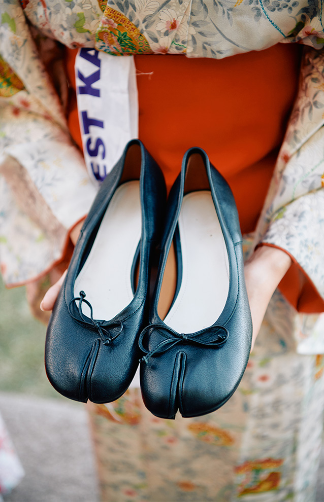 a person holding a pair of traditional Japanese shoes