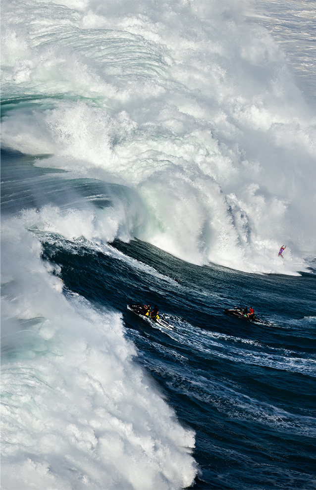 a closeup of a huge wave with someone surfing in it