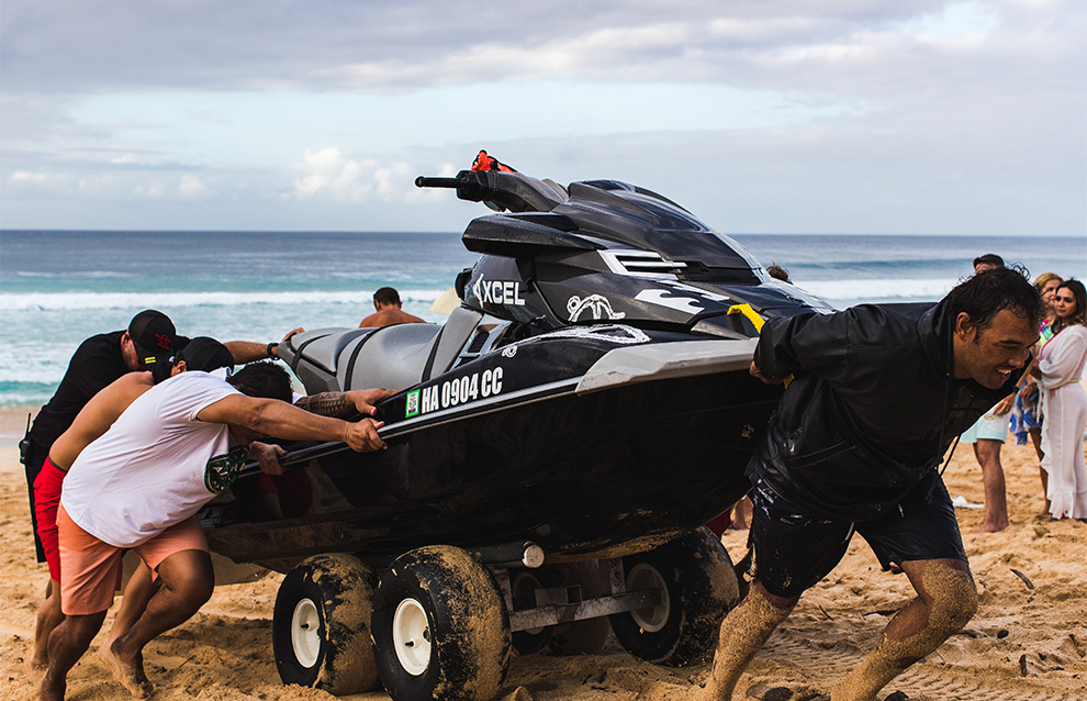 a group of people pushing a small boat onto shore